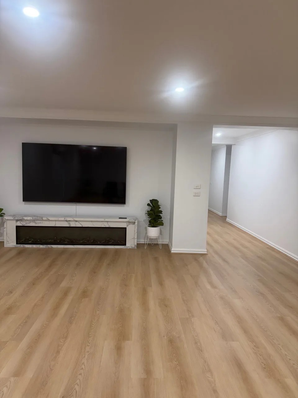 Renewed Epping living space with crisp white walls and warm timber flooring