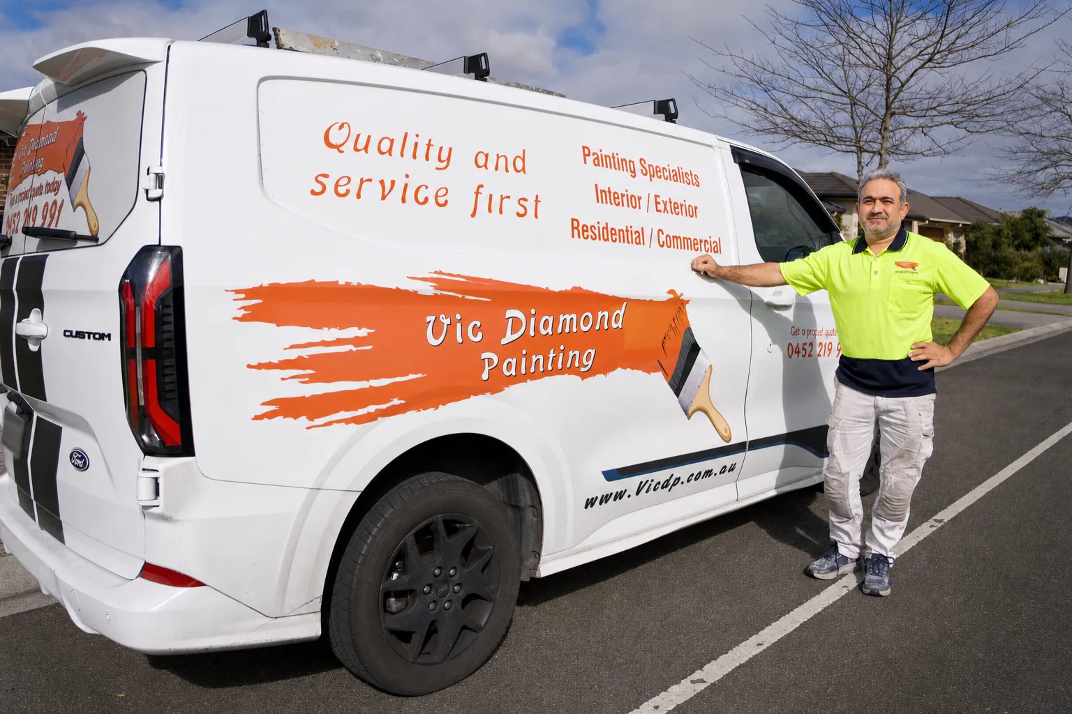 Owner of Vic Diamond Painting standing beside the branded work van